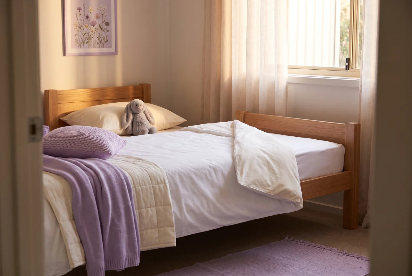A child's bed at dawn, made with dry white sheets