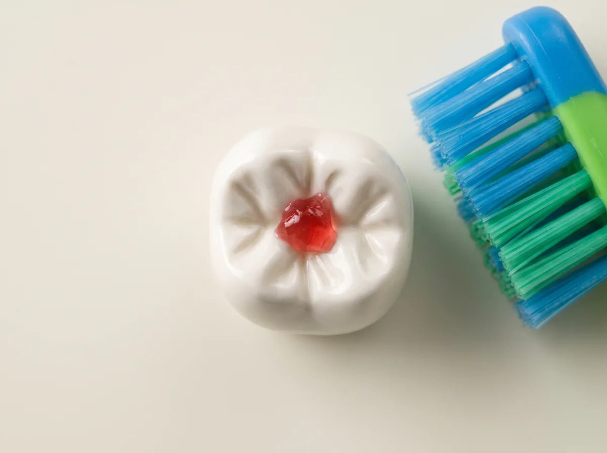 Gummy residue in a molar groove next to a toothbrush that missed it