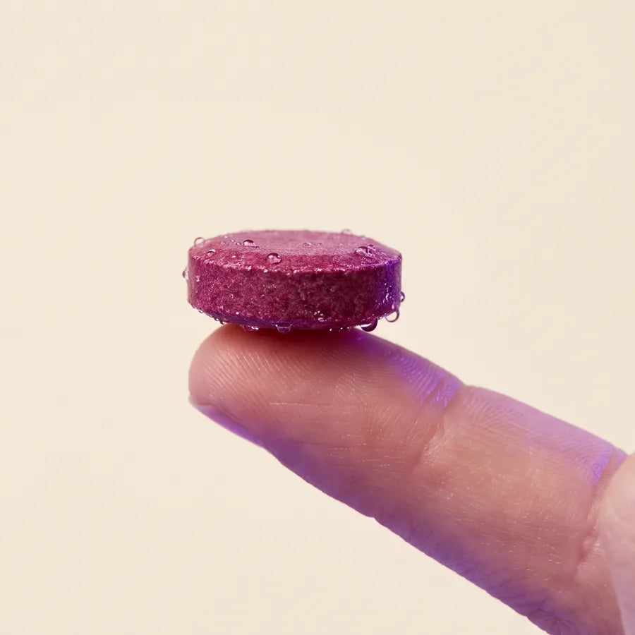 A berry meltable resting on a fingertip